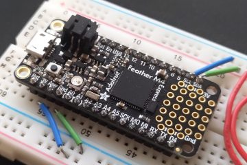 Image showing an Adafruit Feather M4 Express board mounted to a breadboard, with jumper wires around it